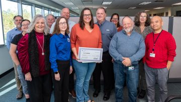 Staff in the Division of Water Supply Planning and Assessment join District Executive Director Mike Register (back center) in presenting the November Employee of the Month award to Joy Kokjohn, center.